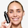 Model holding and showcasing a fair shade of tinted moisturizer