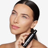 Model holding and showcasing a medium shade of tinted moisturizer
