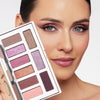 Woman showcasing a diverse eyeshadow palette with shades of purple, pink, and brown, highlighting her elegantly applied eye makeup.