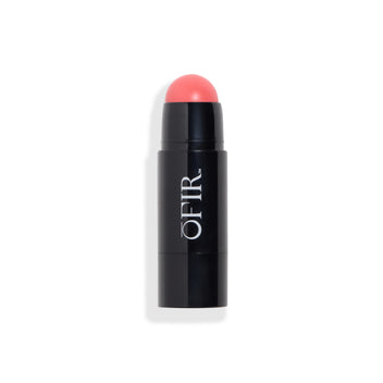 Cream blush stick in a black tube, revealing a rounded blush tip in a coral-pink shade. Blank background