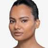 Model showcasing a tan shade of tinted moisturizer