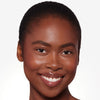Smiling person with clear, glowing skin and glossy lips.
