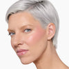 Model showcasing a natural but enhance blonde brow design and color in a radiant natural makeup look.