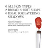 Benefits image for Brush. Text highlights product benefits: "All Skin Types" "Broad, Short Shape" "Ideal for layering shadows". Below text reads "Pack the Pigment. These short, broad fibers grab shadows for precise, fallout-free layering across lids" and "Vegan Fibers. Silky smooth fibers are gentle on skin"
