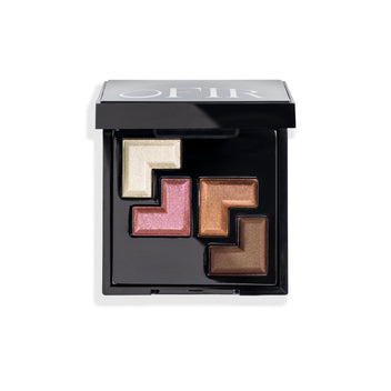 A sleek black makeup palette containing four shimmery eyeshadows in shades of ivory, pink, copper, and brown, arranged in a geometric pattern.