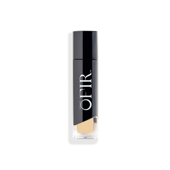 A sleek bottle of OFIR foundation with a modern black and transparent design, showcasing a light beige shade.