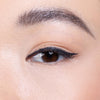 Close-up of an eye with neatly applied black eyeliner and well-groomed eyebrow, highlighting a natural makeup look.