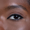 Close-up of a well-defined eye with black eyeliner and mascara, highlighting the texture and tone of the surrounding skin.