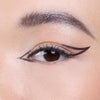 Close-up of an eye showcasing a bold, graphic eyeliner design with clean lines extending beyond the outer corner.