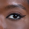 Close-up of an elegantly winged eyeliner on a person's eye, highlighting smooth and flawless skin for a beauty product showcase.