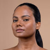 A woman with a smooth, radiant complexion and glossy lips is shown against a neutral background, highlighting skin care and makeup products.