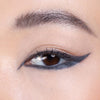 Close-up of a well-defined eye featuring precise black winged eyeliner and natural-looking eyebrows.