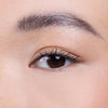 Close-up of a well-groomed eyebrow and eye with natural makeup, showcasing the detail and smooth texture of the skin.