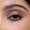 Close-up of a well-defined eye with a natural eyeshadow look, enhanced lashes, and neatly groomed eyebrow.