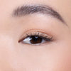 Close-up of a well-groomed eyebrow and eyelash, showcasing a natural makeup look with subtle eye makeup.