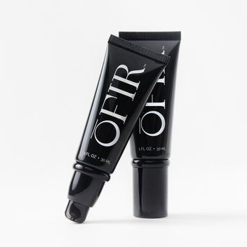 Two OFIR black primer tubes standing on white background