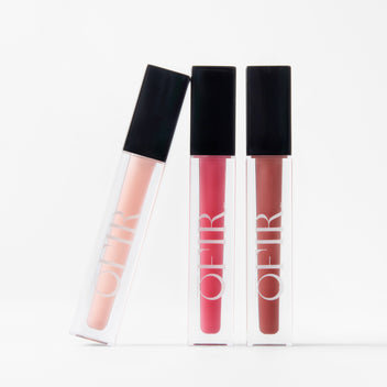 Three OFIR liquid lipsticks in peach, pink, and red tones lined up on white background