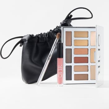 makeup set with black pouch, eyeshadow palette, lip gloss, and brush displayed together