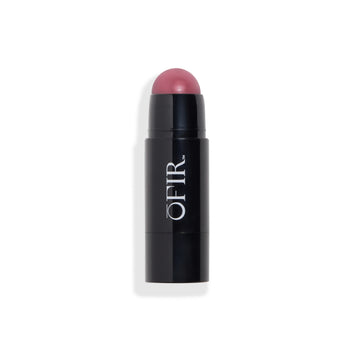 Cream blush stick in a black tube, revealing a rounded blush tip in a purplish shade. Blank background
