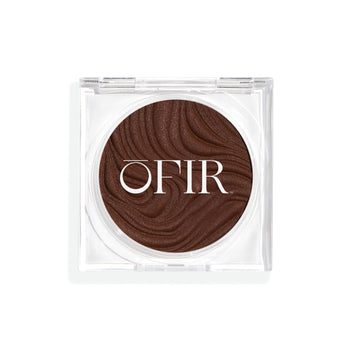 Compact cream bronzer in a dark nude shade with a shiny finish in a transparent case