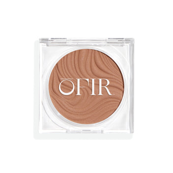 Compact cream bronzer in a fair nude shade with a shiny finish in a transparent case