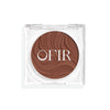 Compact cream bronzer in a medium-dark nude shade with a shiny finish in a transparent case
