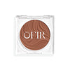Compact cream bronzer in a medium nude shade with a shiny finish in a transparent case
