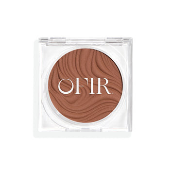 Compact cream bronzer in a medium nude shade with a shiny finish in a transparent case