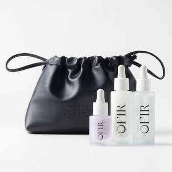 OFIR'S Skincare Bundle. Three OFIR skincare serums (Face Milk, Barrier Drops, and Bloom Serum in lilac)with a black pouch displayed on white background