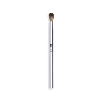 A sleek eyeshadow blending brush with a silver handle and soft, rounded bristles.