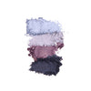 Four swatches of crushed eyeshadow in shades of blue, silver, mauve, and navy, arranged vertically on a white background.