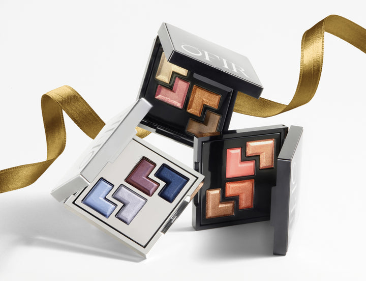 OFIR eyeshadow palettes arranged with a gold ribbon on a white background