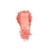 Crumpled coral-colored powder featuring a smooth, flat central section with scattered edges, suitable for cosmetic applications.