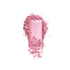 Pink cosmetic powder texture, finely milled and scattered, showcasing its soft and blendable consistency on a white background.