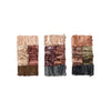Three palettes of crushed eyeshadow featuring a variety of shades, including neutral browns, shimmering golds, deep reds, and smoky grays, arranged vertically against a white background.