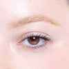 Close-up of a well-groomed eyebrow and eye with subtle makeup, highlighting smooth skin and natural lashes.