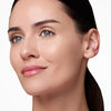 Smiling person with smooth, radiant skin and glossy lips.