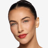 Model showcasing a rose brick shade of lip gloss