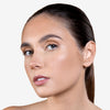 Close-up of a person with smooth, glowing skin and natural makeup, showcasing a radiant complexion against a neutral background.