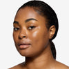 Model showcasing a natural but enhance black brow design and color in a radiant natural makeup look.