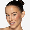Model showcasing a pink/light brown-ish blush pigmentation in a radiant natural makeup look.