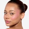 Model showcasing a purplish blush pigmentation in a radiant natural makeup look.