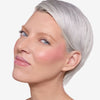 Model  showcasing a pink blush pigmentation in a radiant natural makeup look.