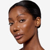 Model showcasing a tan to dark bronze makeup pigmentation 
