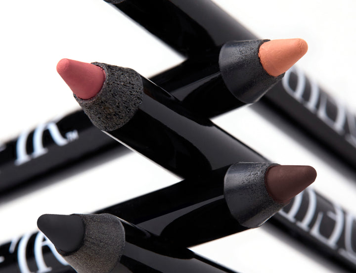 Close-up of OFIR lip and eye liner tips in peach, pink, brown, and black shades