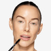 Model applying OFIR Lip Line longwear demi-matte lip pencil in Off Pink shade