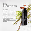 Black bottle of skincare product with key ingredients listed: Allantoin for improving skin texture, Sodium Hyaluronate for reducing fine lines, and Theobroma Cocoa Seed Extract for environmental protection. Botanical elements like aloe, cucumber slices, and cocoa beans are displayed beside the bottle.