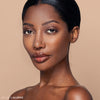 Model showcasing a natural makeup look with smooth, radiant skin, wearing subtle lip gloss and eyeshadow.