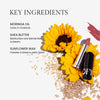 Key ingredients listed are moringa oil for moisture retention, shea butter for blending and hydration, and sunflower wax for a satin finish. Accompanying elements include vibrant sunflowers, scattered seeds, and a lipstick tube with a rosy swatch nearby.