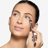 Model applying makeup under her eye using a dual-ended silver makeup brush 